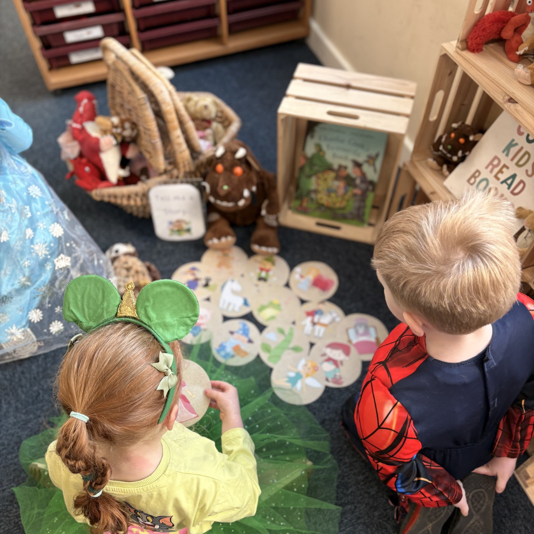 two children in world book day fancy dress looking at books